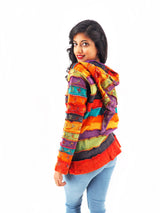 a woman wearing a colorful jacket and jeans