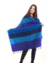 Handmade Yak Wool Shawl Throw in blue and purple hues, draped over shoulders. Multi-use, ethical, and perfect as a meditation shawl or blanket.