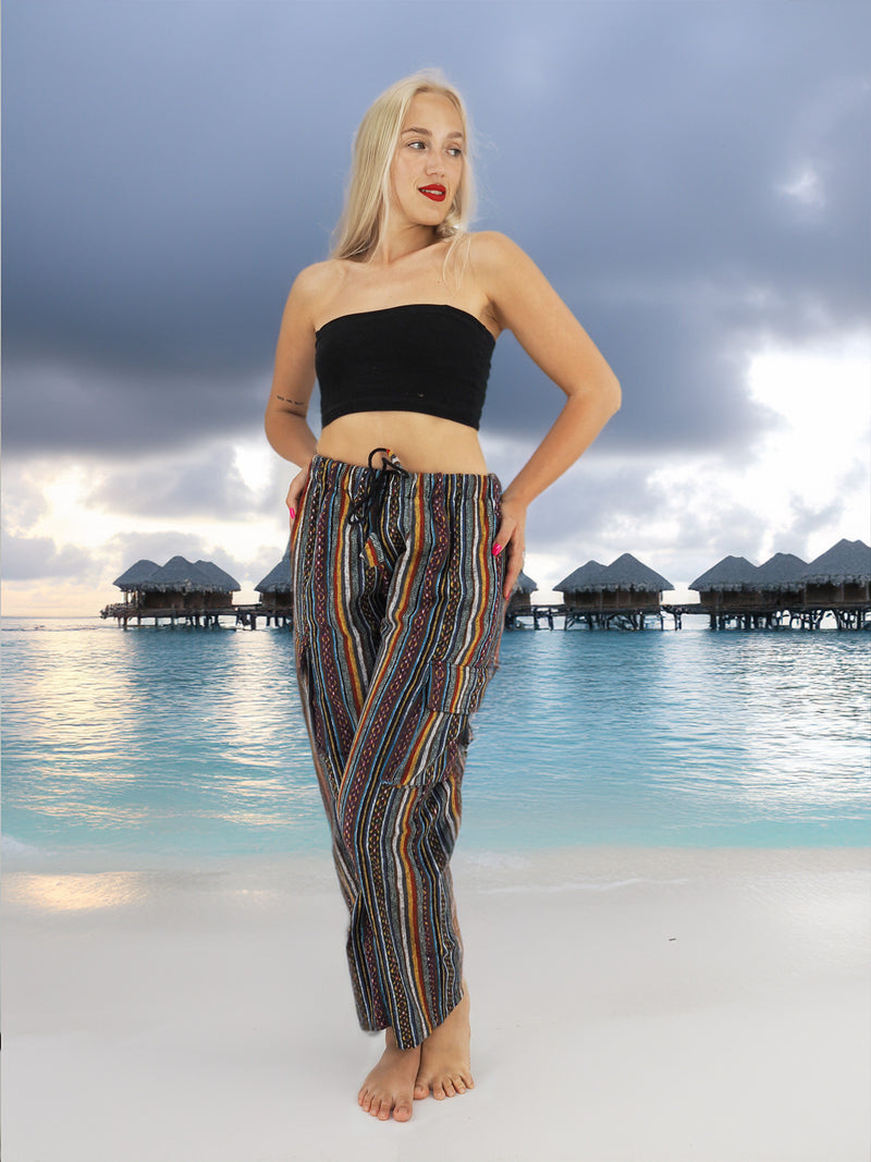 a woman standing on a beach with her hands on her hips