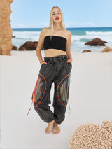 Model wearing boho yoga pants on sandy beach