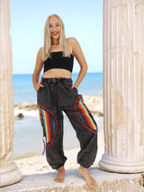 Handmade gray hippie pants with colorful stripes by beach