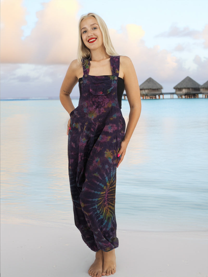 a woman standing on a beach in a purple dress