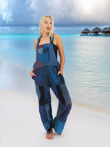 a woman standing on a beach in a blue jumpsuit