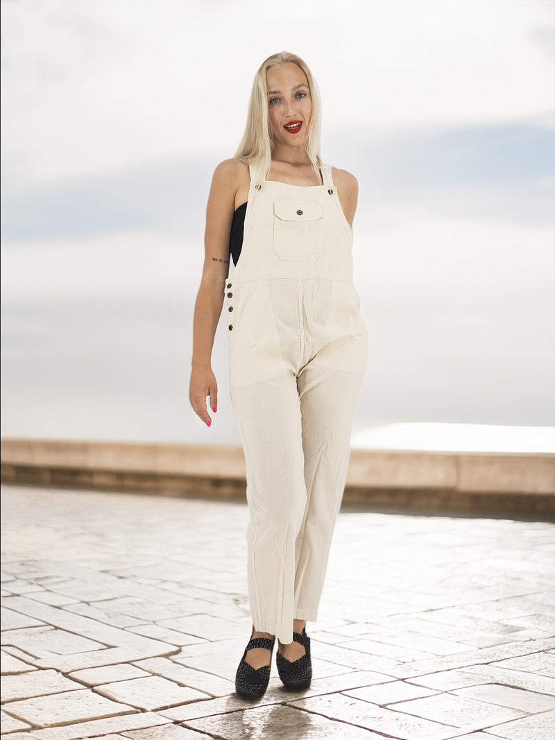 a woman with blonde hair wearing overalls and a black top