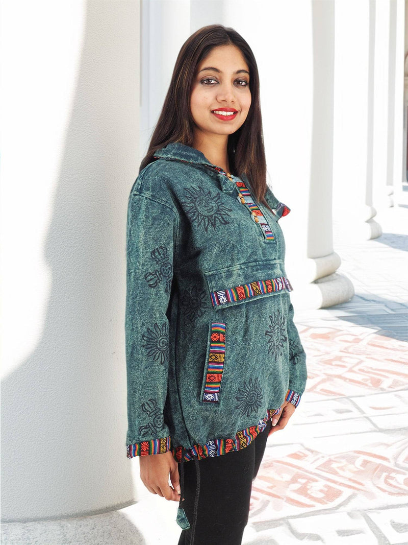 a woman standing next to a wall wearing a green jacket