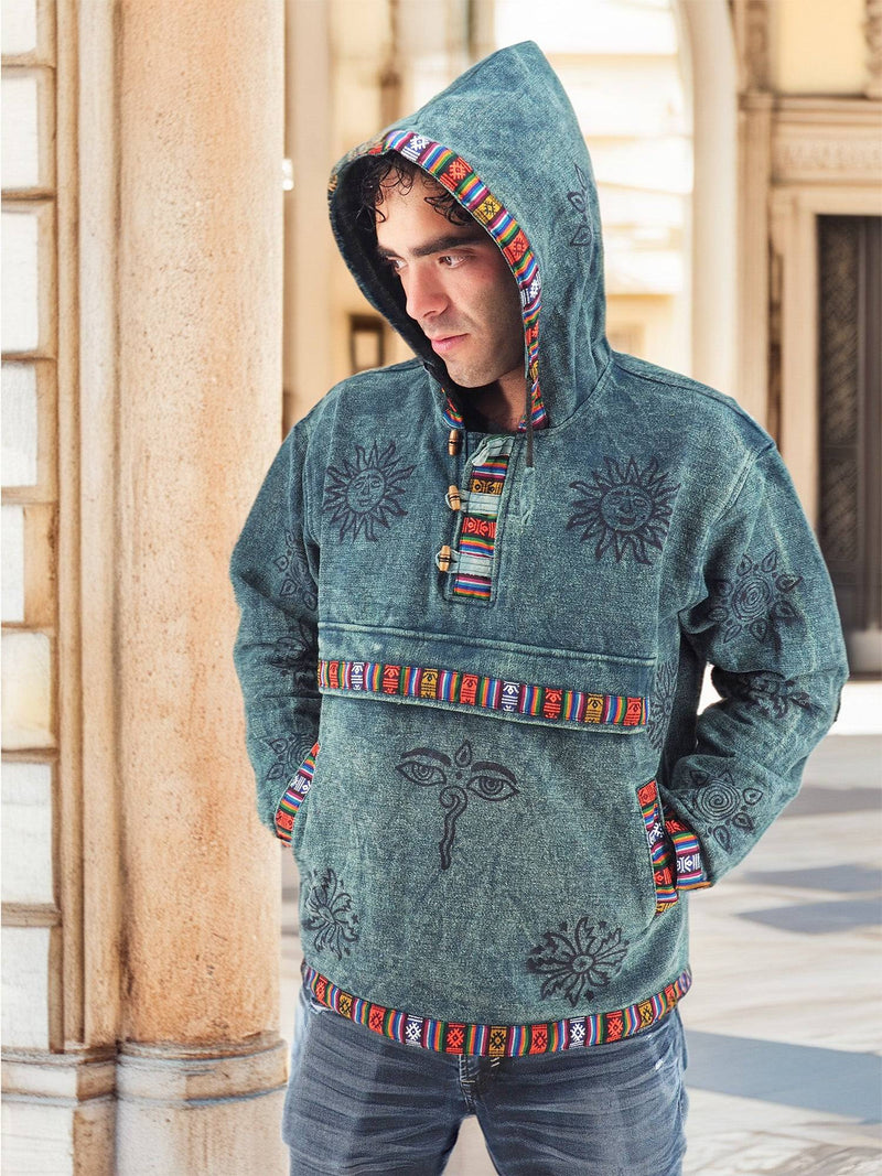 a man in a blue hoodie standing in front of a pillar