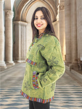 a woman in a green jacket standing in a hallway