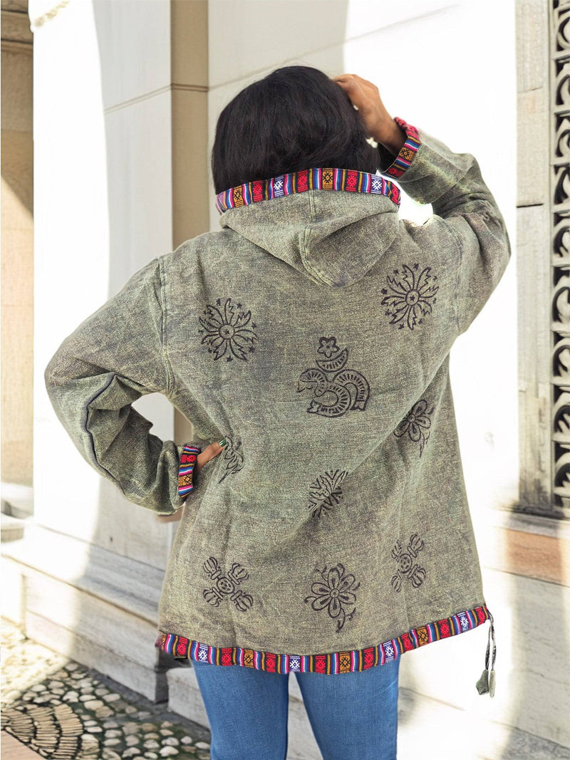 a woman standing on a sidewalk wearing a jacket