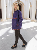 a woman in a purple coat is walking