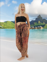 a woman standing on a beach wearing a crop top and pants