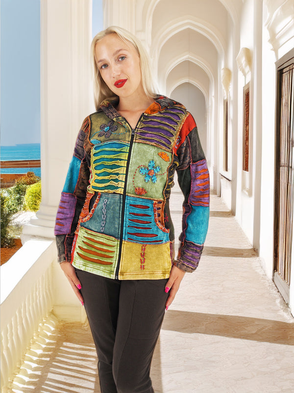 Model wearing a colorful bohemian style hoodie with hand embroidery, pattern, applique, and crochet work, made by women artisans in Nepal. The hoodie has a unique vintage look due to the stonewash process.