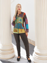 Vibrant bohemian patchwork hoodie, pre-washed cotton, S-XXL sizes, model in studio setting with architectural columns