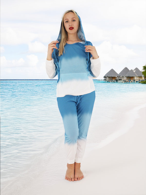 a woman in a blue and white outfit standing on a beach